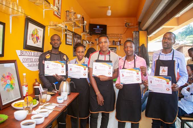 Graduates holding Bonny Barista certificates